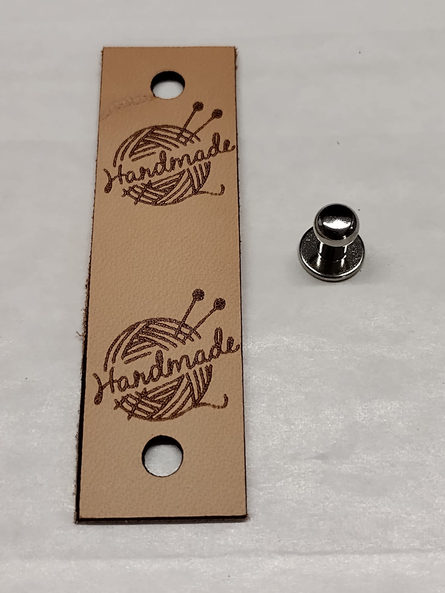 Nahkainen handmade -merkki niitillä