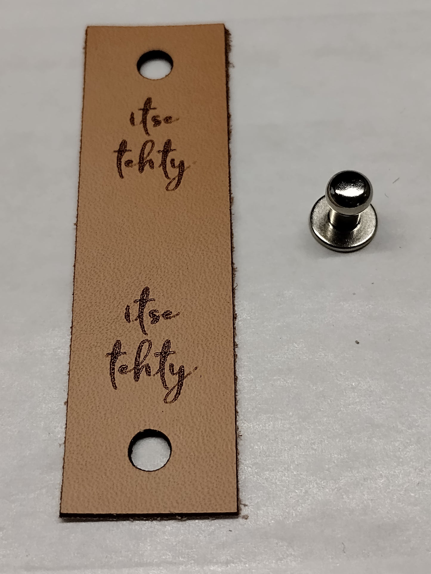 Nahkainen handmade -merkki niitillä